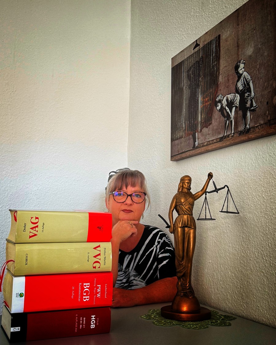 Sandra Umlauf am Schreibtisch, Gesetzeskommentare und eine Justitia-Figur im Büro von Team Pachel